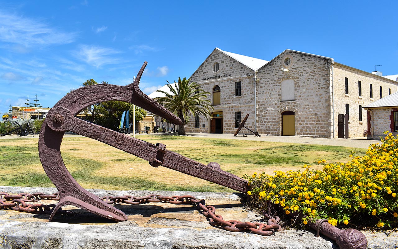 There is an anchor in front of the Shipwrecks Museum